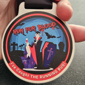 Halloween-themed running medal with vampire illustration