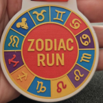 Colourful Zodiac Run circular badge with star signs