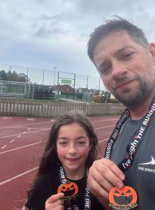 Man and girl with Pumpkin 5K medals