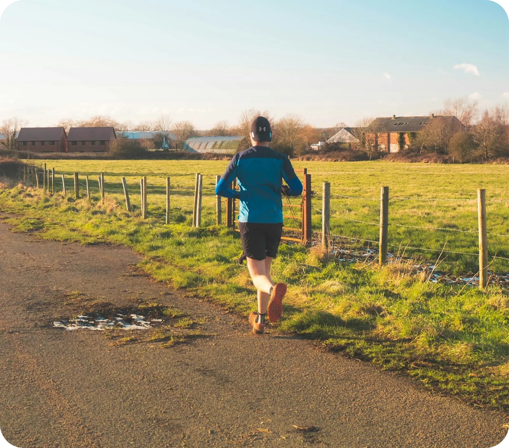 Runner on a rural path beside sunlit fields