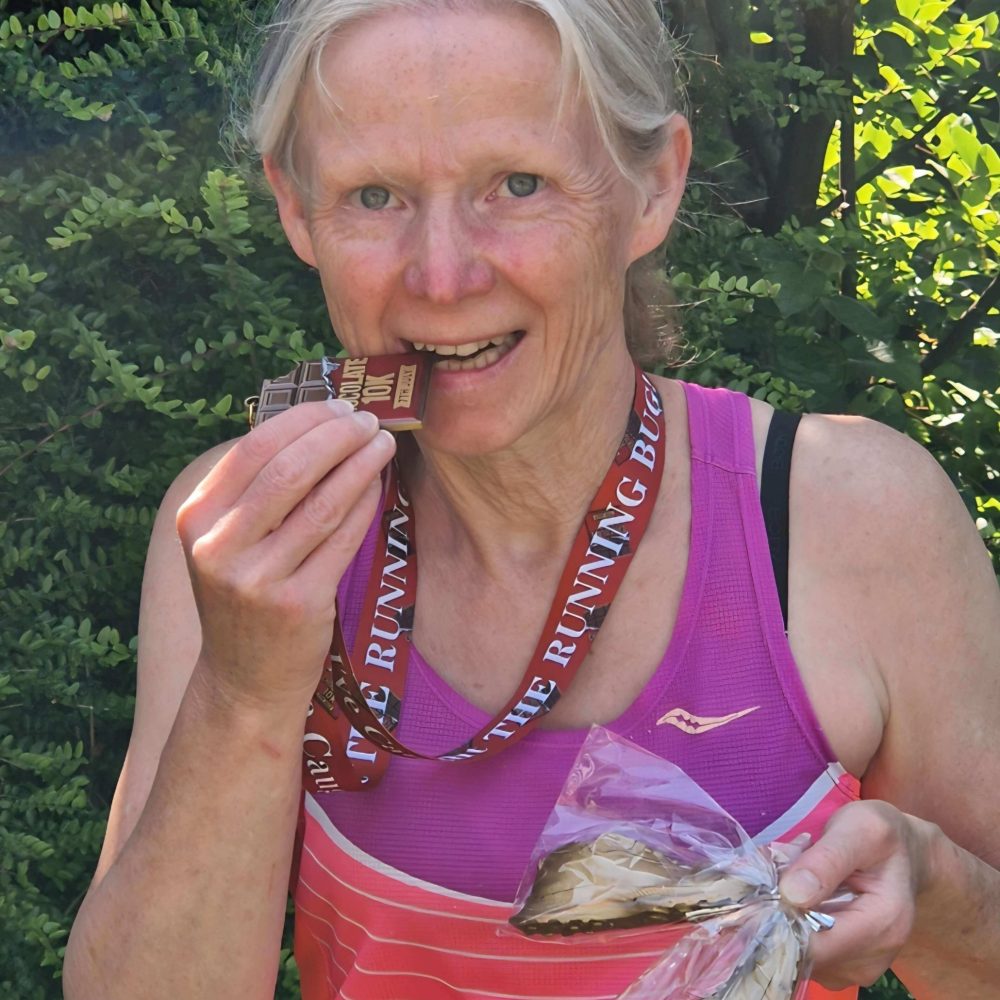 Woman in running gear eating chocolate outdoors